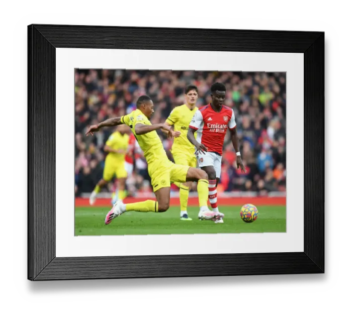 Framed Print : Arsenal's Bukayo Saka Faces Off Against Brentford's Ethan Pinnock in Premier League Clash Framed Print : Arsenal's Bukayo Saka Faces Off Against Brentford's Ethan Pinnock in Premier League Clash