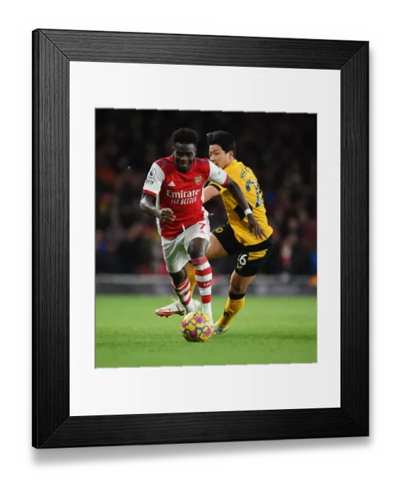 Framed Print : Arsenal's Bukayo Saka Outmaneuvers Wolves Hwang Hee-Chan in Premier League Clash