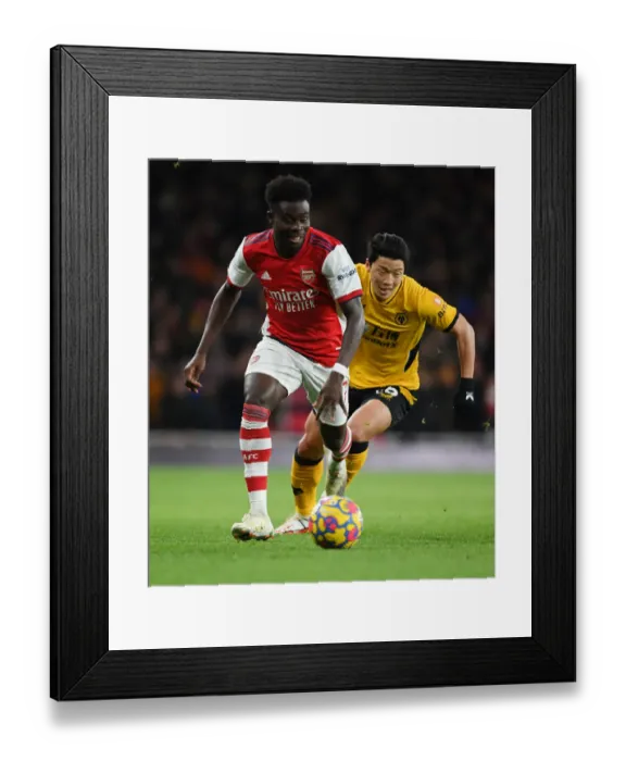 Framed Print : Bukayo Saka's Agile Moves: Outsmarting Hwang Hee-Chan in a Thrilling Arsenal Victory Framed Print : Bukayo Saka's Agile Moves: Outsmarting Hwang Hee-Chan in a Thrilling Arsenal Victory