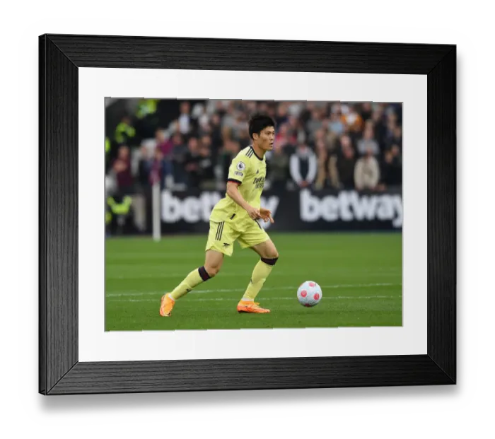 Framed Print : Arsenal's Tomiyasu in Action against West Ham in Premier League Showdown