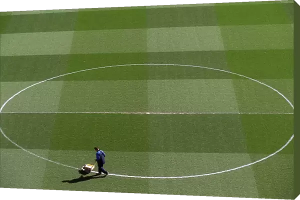 Groundsman Paul Burgess marks out the pitch before the match