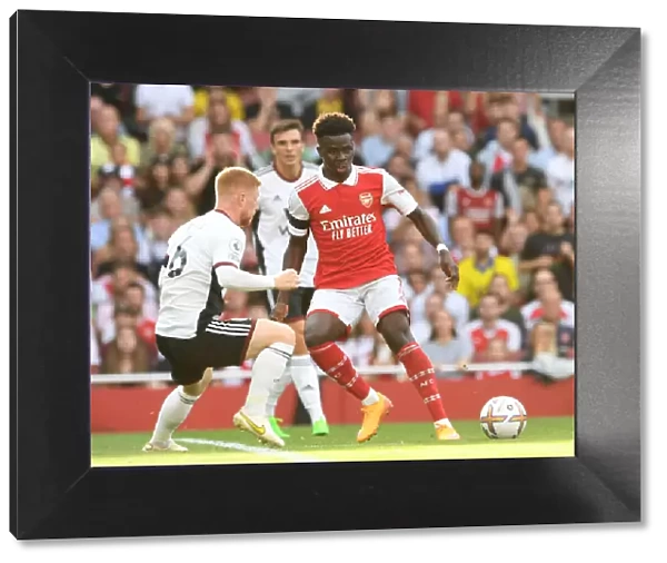 Arsenal's Bukayo Saka Fends Off Fulham's Harrison Reed in Premier League Clash