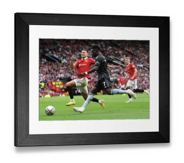 Framed Print : Bukayo Saka vs Diogo Dalot: Intense Battle at Old Trafford - Manchester United vs Arsenal, Premier League 2022-23