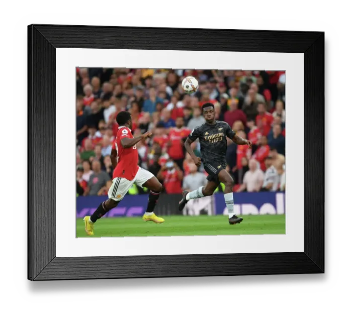 Framed Print : Nketiah vs Malacia: A Premier League Battle at Old Trafford Framed Print : Nketiah vs Malacia: A Premier League Battle at Old Trafford