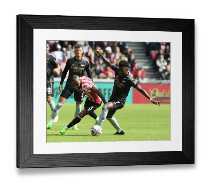 Framed Print : Bukayo Saka vs Rico Henry: Intense Battle at Brentford Community Stadium - Arsenal vs Brentford, Premier League 2022-23