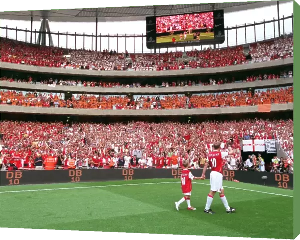 Dennis Bergkamp (Arsenal) waves to the fans on a lap of honour with his son at the end of the match