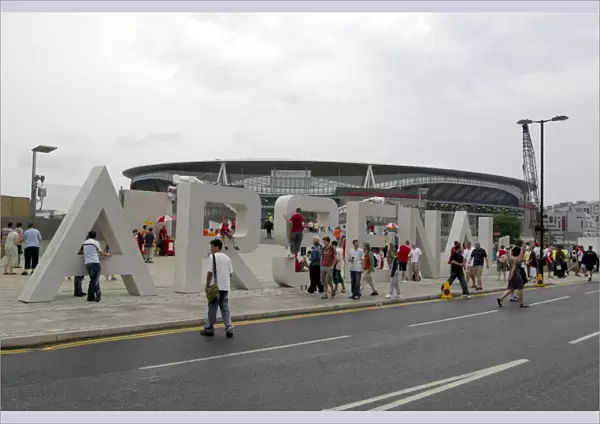 Arsenal fans gather around the giant letters near the south bridge outside the Emirates Stadium