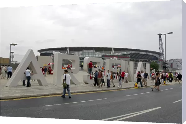 Arsenal fans gather around the giant letters near the south bridge outside the Emirates Stadium