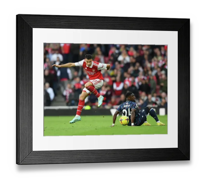 Framed Print : Arsenal's Martinelli Leaps Past Forest's Aurier in Premier League Clash Framed Print : Arsenal's Martinelli Leaps Past Forest's Aurier in Premier League Clash