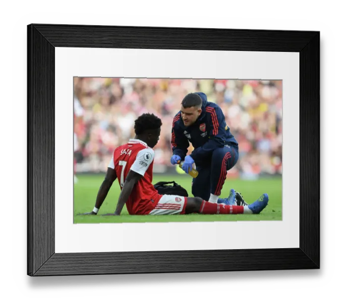 Framed Print : Arsenal's Bukayo Saka Receives Treatment vs Nottingham Forest (2022-23) Framed Print : Arsenal's Bukayo Saka Receives Treatment vs Nottingham Forest (2022-23)