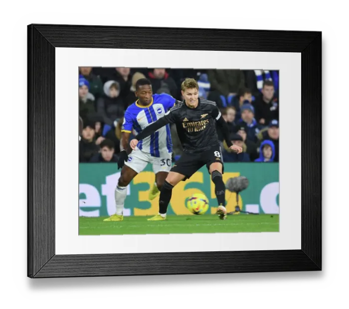Framed Print : Martin Odegaard Breaks Past Brighton's Pervis Estupinan in Arsenal's Premier League Clash