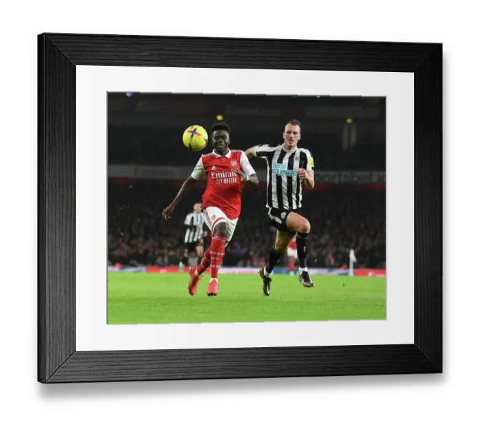 Framed Print : Arsenal's Bukayo Saka vs. Newcastle's Dan Burn: A Premier League Battle at Emirates Stadium