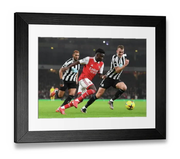 Framed Print : Arsenal's Bukayo Saka Outmaneuvers Newcastle's Dan Burn in Premier League Clash Framed Print : Arsenal's Bukayo Saka Outmaneuvers Newcastle's Dan Burn in Premier League Clash