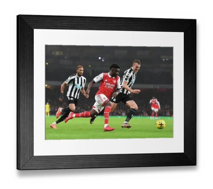 Framed Print : Arsenal's Bukayo Saka Outsmarts Newcastle's Dan Burn: A Premier League Tactical Showdown