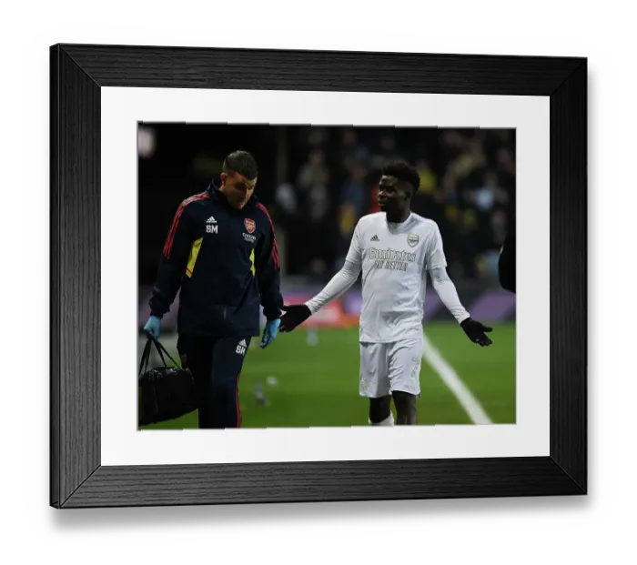 Framed Print : Arsenal's Bukayo Saka Receives Medical Attention from Physio During FA Cup Match against Oxford United Framed Print : Arsenal's Bukayo Saka Receives Medical Attention from Physio During FA Cup Match against Oxford United