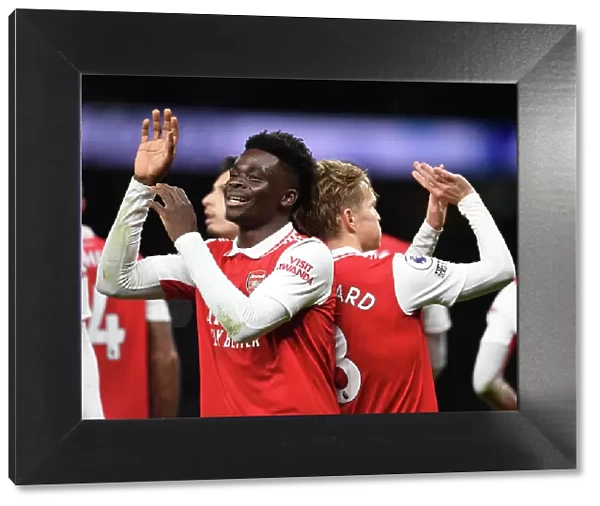 Arsenal's Unstoppable Duo: Martin Odegaard and Bukayo Saka Celebrate Goal Against Tottenham in the 2022-23 Premier League