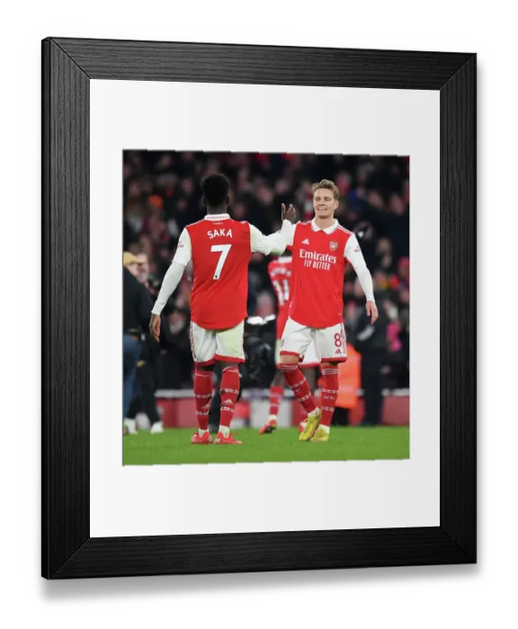Framed Print : Arsenal's Odegaard and Saka Celebrate Victory Over Manchester United in 2022-23 Premier League