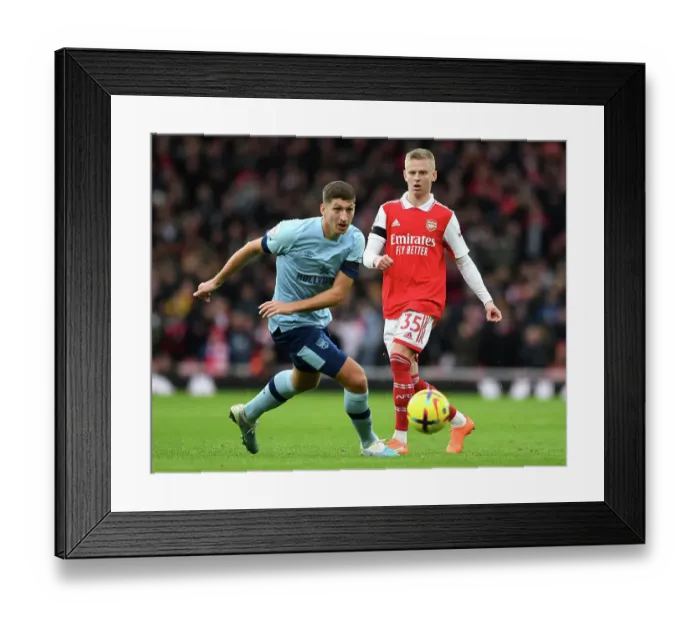 Framed Print : Arsenal's Zinchenko Fends Off Brentford's Janelt in Premier League Clash Framed Print : Arsenal's Zinchenko Fends Off Brentford's Janelt in Premier League Clash