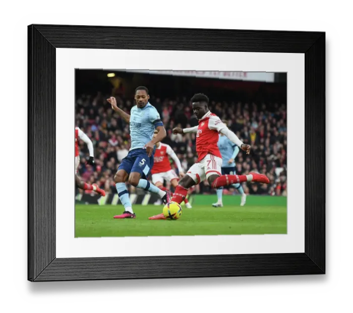 Framed Print : Arsenal's Bukayo Saka Clashes with Brentford's Ethan Pinnock in Premier League Showdown