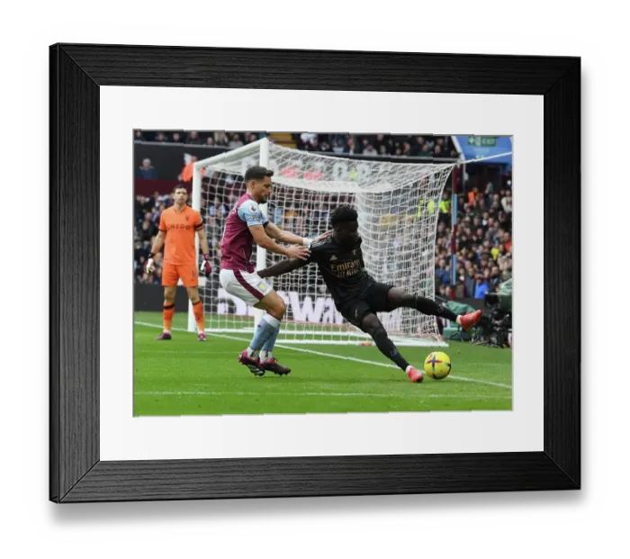 Framed Print : Bukayo Saka vs Alexandre Moreno: Intense Battle at Villa Park - Arsenal vs Aston Villa, Premier League 2022-23
