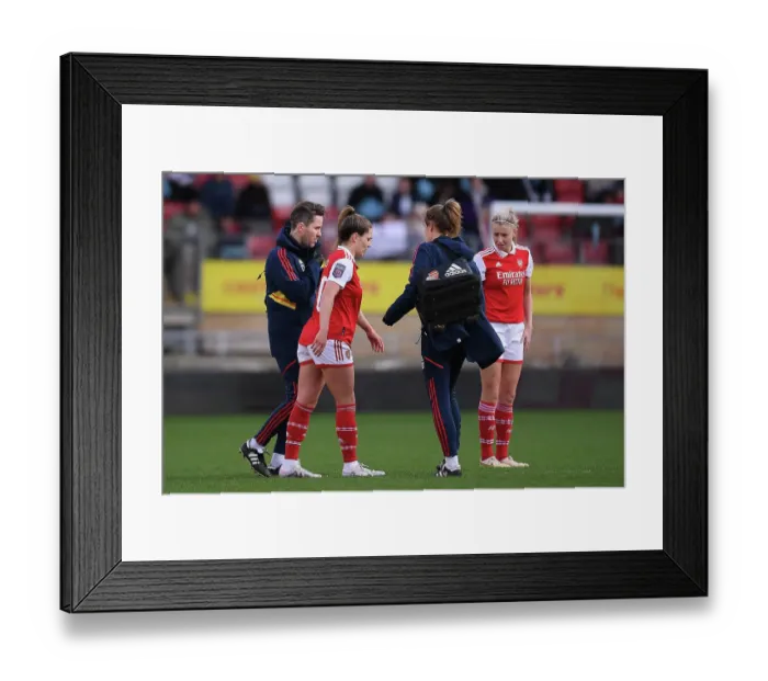 Framed Print : Arsenal's Gio Queiroz Receives Medical Treatment During Tottenham vs Arsenal Women's Super League Match