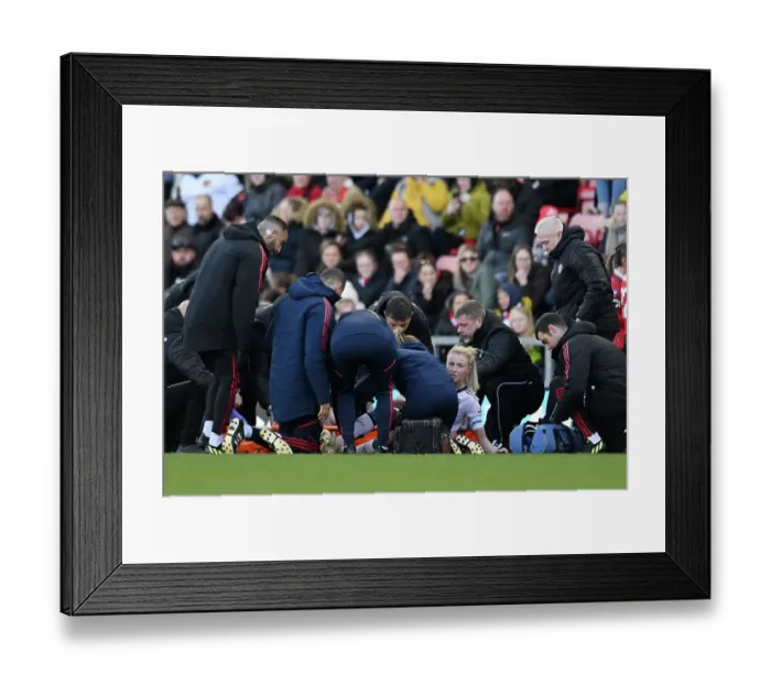 Framed Print : Arsenal's Leah Williamson Receives Medical Attention During Manchester United vs Arsenal Women's Super League Match