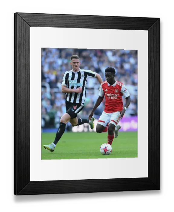 Framed Print : Bukayo Saka vs Sven Botman: Intense Battle at St. James Park - Arsenal vs Newcastle, Premier League 2022-23