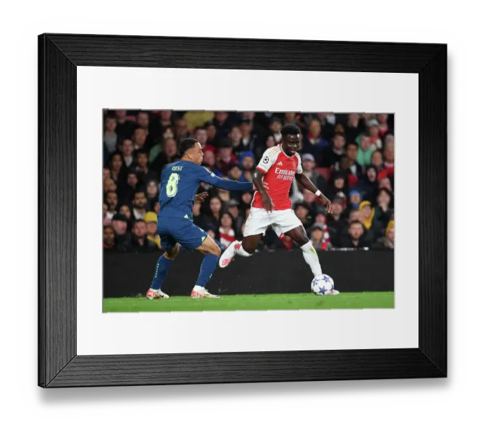 Framed Print : Arsenal's Bukayo Saka Fends Off PSV's Sergino Dest in Champions League Clash