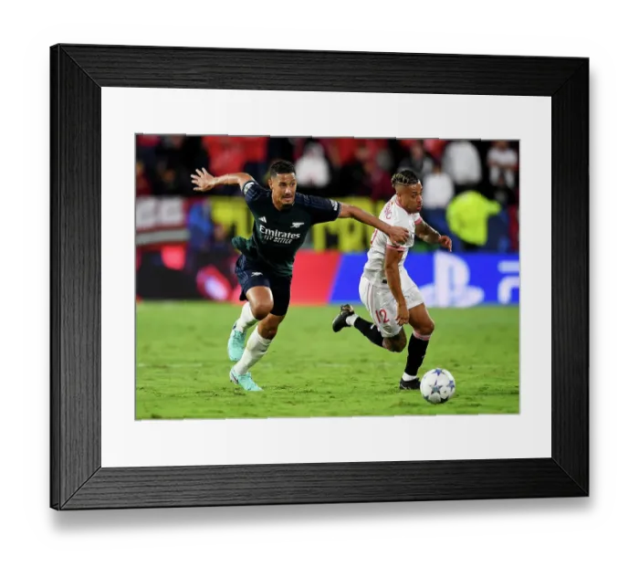 Framed Print : Battle for Possession: Sevilla vs. Arsenal - Arsenal's William Saliba Fights for the Ball against Mariano in the 2023 / 24 UEFA Champions League Framed Print : Battle for Possession: Sevilla vs. Arsenal - Arsenal's William Saliba Fights for the Ball against Mariano in the 2023 / 24 UEFA Champions League