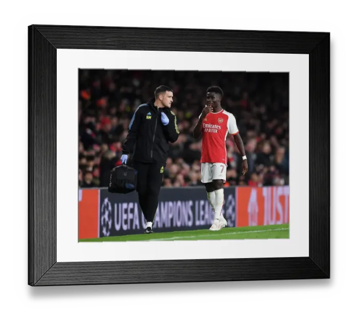 Framed Print : Arsenal FC vs Sevilla FC: Bukayo Saka Receives Medical Attention in Group B - UEFA Champions League 2023 / 24