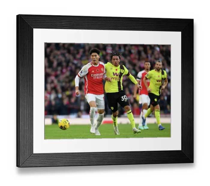 Framed Print : Arsenal's Tomiyasu Fends Off Burnley's Pressure in Premier League Clash