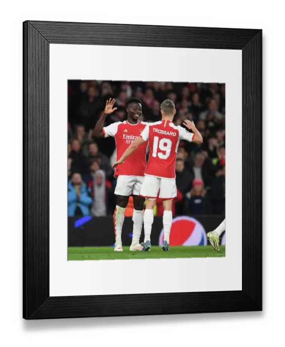 Framed Print : Arsenal's Bukayo Saka and Leandro Trossard Celebrate Goals Against Sevilla in 2023-24 UEFA Champions League