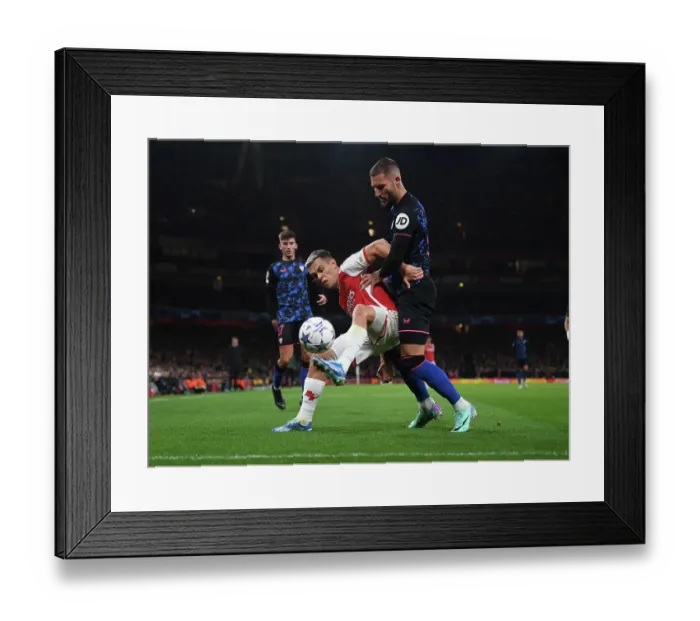 Framed Print : Arsenal's Trossard Fends Off Sevilla's Gudelj in Intense UCL Showdown