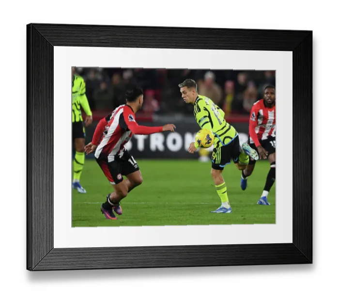 Framed Print : Arsenal's Trossard Scores Past Brentford's Ghoddos in Premier League Clash (2023-24)