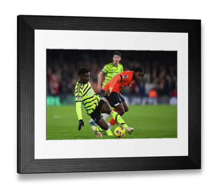 Framed Print : Bukayo Saka vs Teden Mengi: Intense Battle in Luton Town vs Arsenal FC, Premier League 2023-24