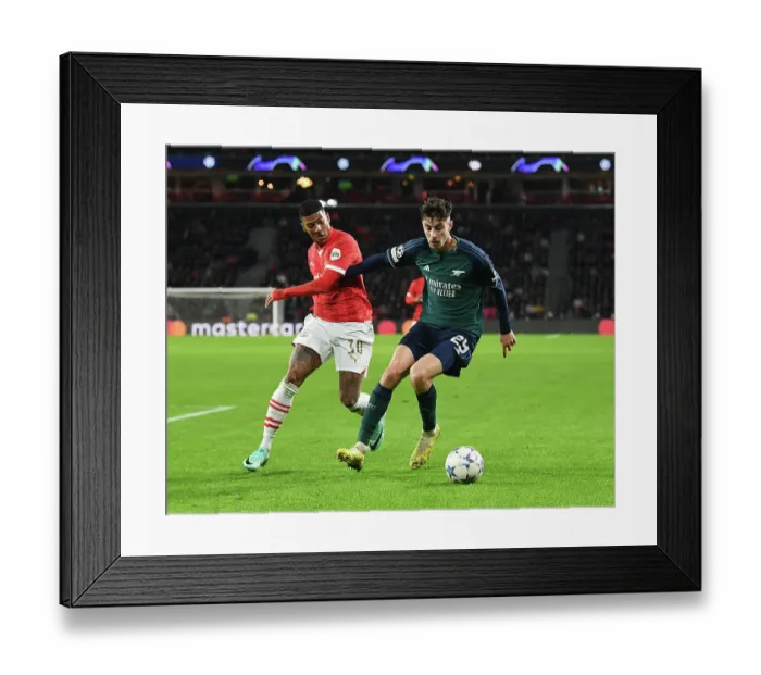 Framed Print : Arsenal's Kai Havertz Faces Off Against PSV's Patrick van Aanholt in Champions League Clash