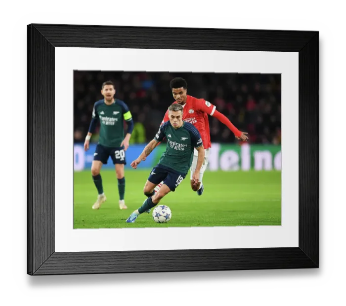 Framed Print : Arsenal's Trossard Faces Off Against PSV's Tillman in Champions League Clash