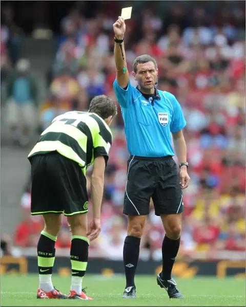 Referee Andre marriner shows a yellow card to Charlie Mulgrew (Celtic)