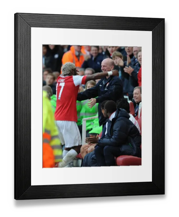 Framed Print : Alex Song celebrates scoring the Arsenal goal with masseur John Kelly. Arsenal 1