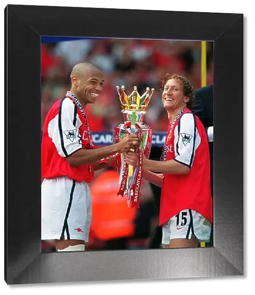 Thierry Henry and Ray Parlour lift the F. A. Barclaycard Premiership Trophy