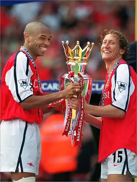 Thierry Henry and Ray Parlour lift the F. A. Barclaycard Premiership Trophy