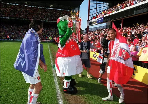 Gunner lifts the Premiership trophy watched by Thierry Henry and Robert Pires