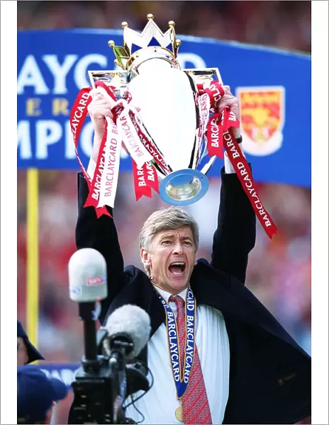Arsenal manager Arsene Wenger lifts the F. A. Barclaycard Premiership Trophy