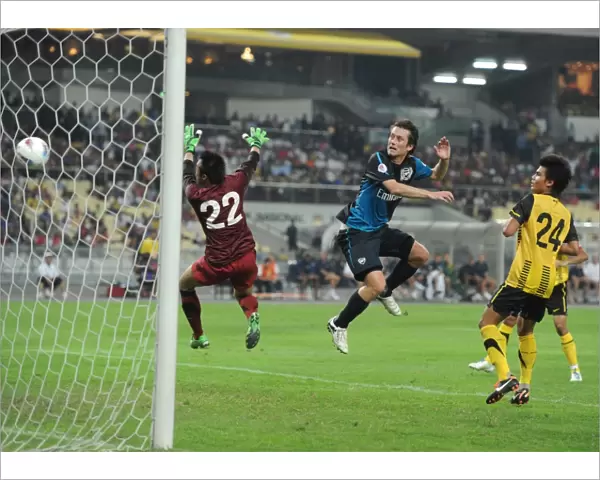Tomas Rosicky heads past Malaysia goalkeeper Khairul Che Mat to score the 4th Arsenal goal