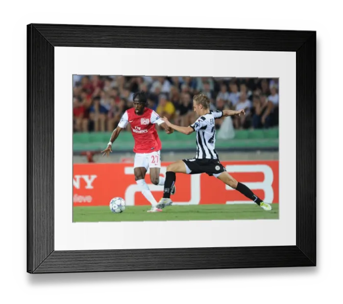 Framed Print : Gervinho vs. Ekstrand: Battle at the Stadio Friuli - Udinese vs. Arsenal, UEFA Champions League Play-Off, 2011