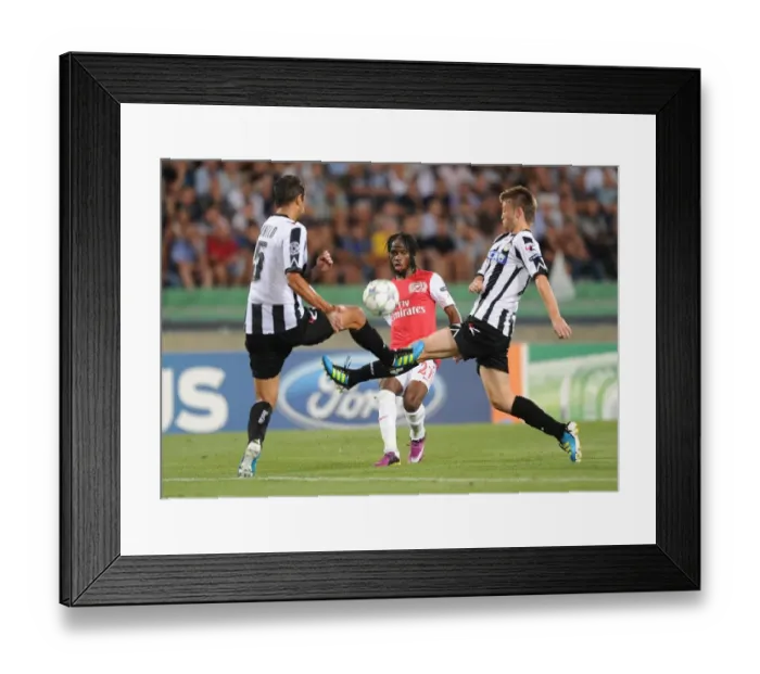 Framed Print : Gervinho Faces Off Against Neuton and Danilo Larangeria in Udinese vs Arsenal UEFA Champions League Clash