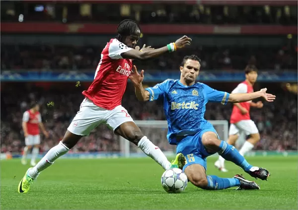 Arsenal's Gervinho Clashes with Marseille's Jeremy Morel in UEFA Champions League Showdown