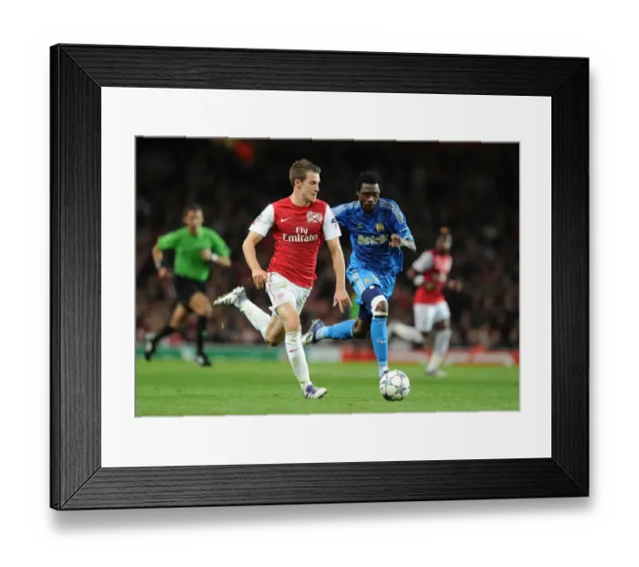 Framed Print : Arsenal's Aaron Ramsey Outmaneuvers Marseille's Koulouté in 2011-12 Champions League Clash Framed Print : Arsenal's Aaron Ramsey Outmaneuvers Marseille's Koulouté in 2011-12 Champions League Clash
