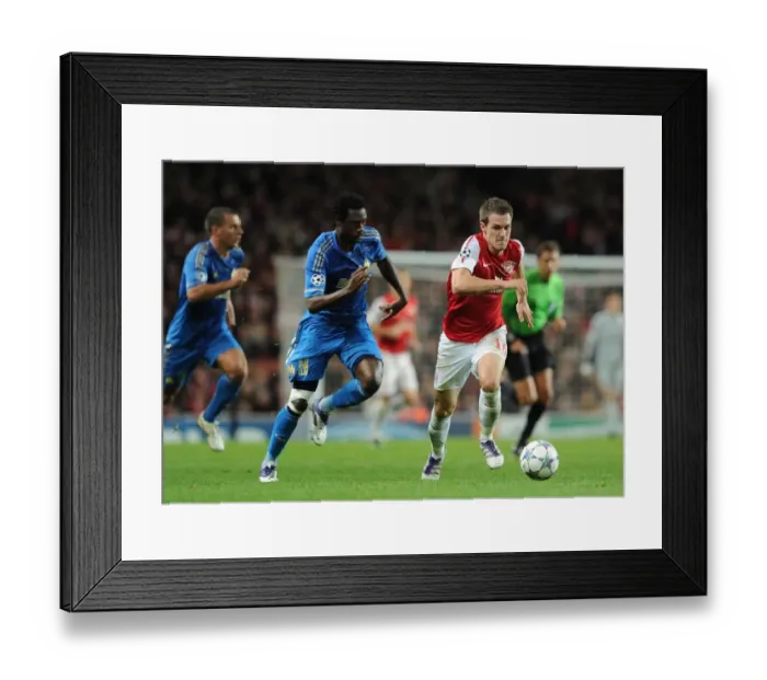 Framed Print : Arsenal's Aaron Ramsey Outsmarts Koulouté: A Thrilling 2011-12 Champions League Showdown Framed Print : Arsenal's Aaron Ramsey Outsmarts Koulouté: A Thrilling 2011-12 Champions League Showdown