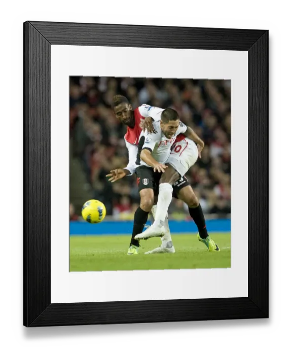 Framed Print : Arsenal's Johan Djourou Faces Off Against Fulham's Clint Dempsey in Premier League Clash Framed Print : Arsenal's Johan Djourou Faces Off Against Fulham's Clint Dempsey in Premier League Clash
